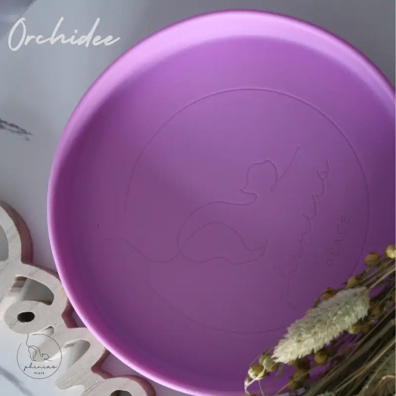 Runder violetter Teller mit geprägtem Design.