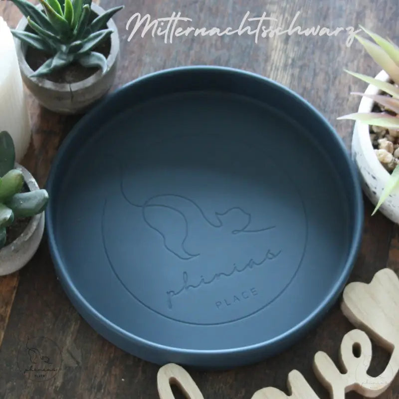 Runder, dunkelblauer Haustiernapf mit Katzenmotiv.
